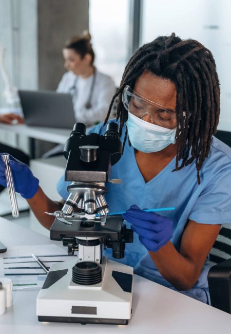 Process of using microscope. Doctors are in the clinic.